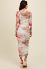 woman wearing a long sleeve printed midi dress with a colorful marble pattern and a fitted silhouette