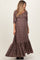 woman wearing a brown floral maternity maxi dress with puff sleeves and a tiered skirt, showing her baby bump