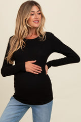 woman wearing a black ribbed long sleeve maternity top and holding her baby bump
