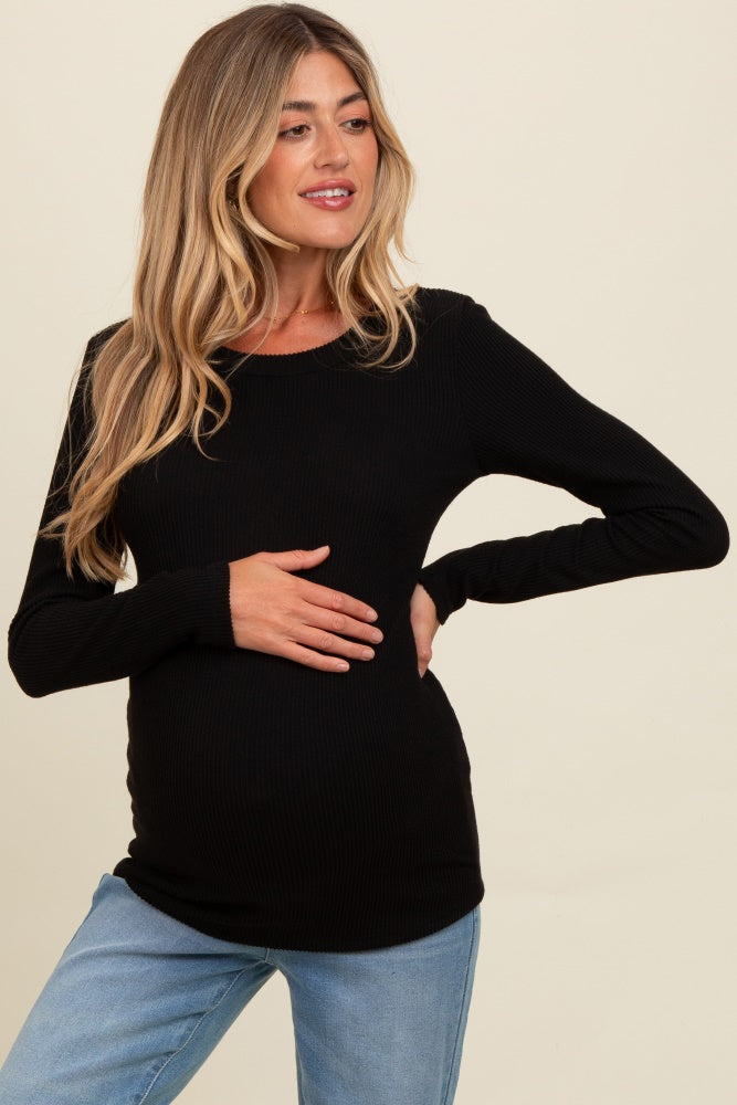 woman wearing a black ribbed long sleeve maternity top and holding her baby bump