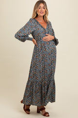 woman wearing a floral print maternity maxi dress with long sleeves and a baby bump visible