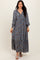 woman wearing a navy blue floral maxi dress with long sleeves and a v-neckline, standing against a neutral background