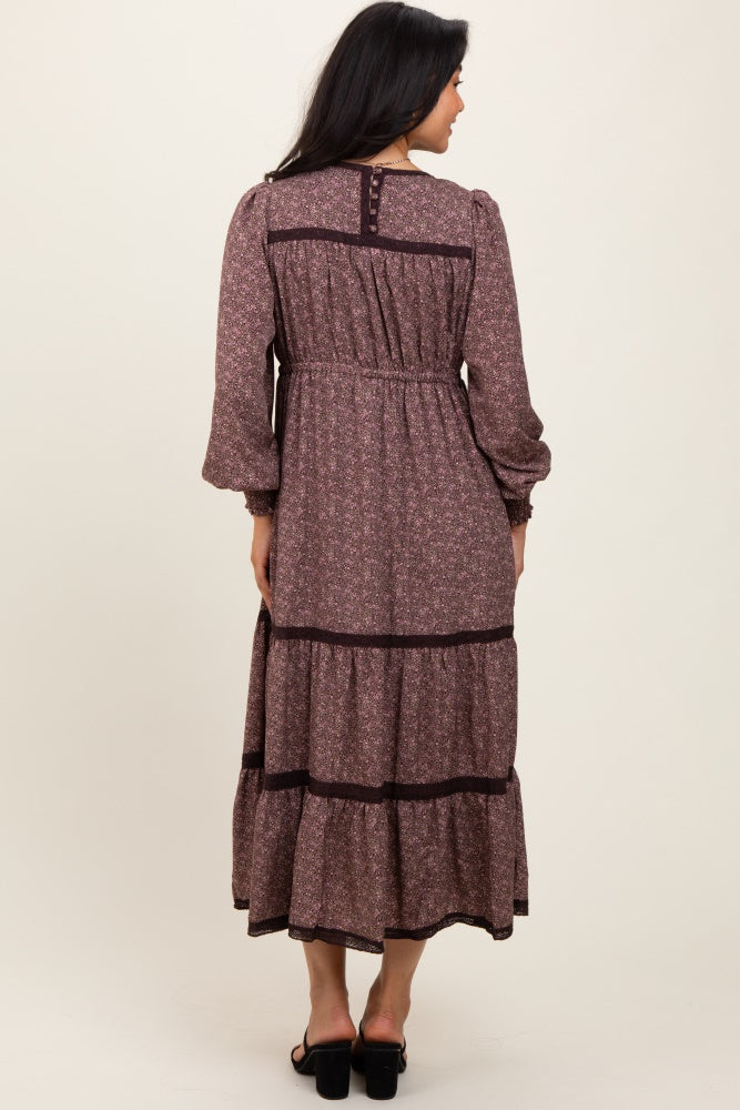 woman wearing a maroon floral maxi dress with long sleeves and tiered ruffles, seen from the back