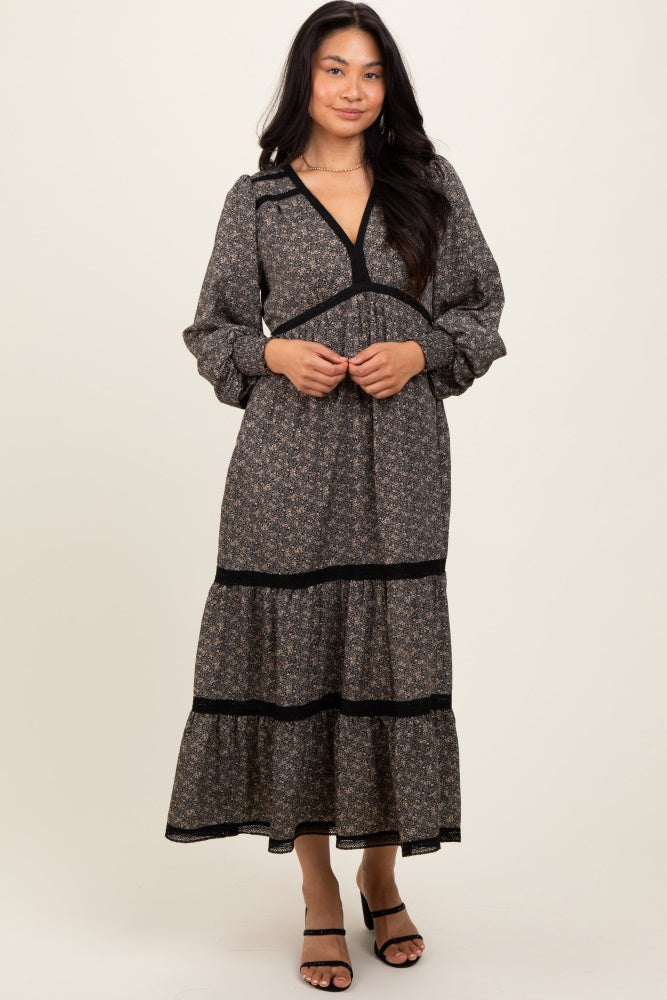 woman wearing a black floral long sleeve maxi dress with a tiered skirt and a v-neckline