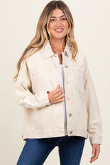 woman wearing a light beige maternity jacket with button details and side pockets over a white top and jeans