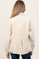 woman wearing a beige maternity jacket with a back pleat and button details, shown from the back