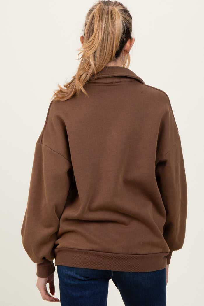 woman wearing a brown oversized maternity sweatshirt with a relaxed fit and long sleeves, showing her pregnant belly from the back