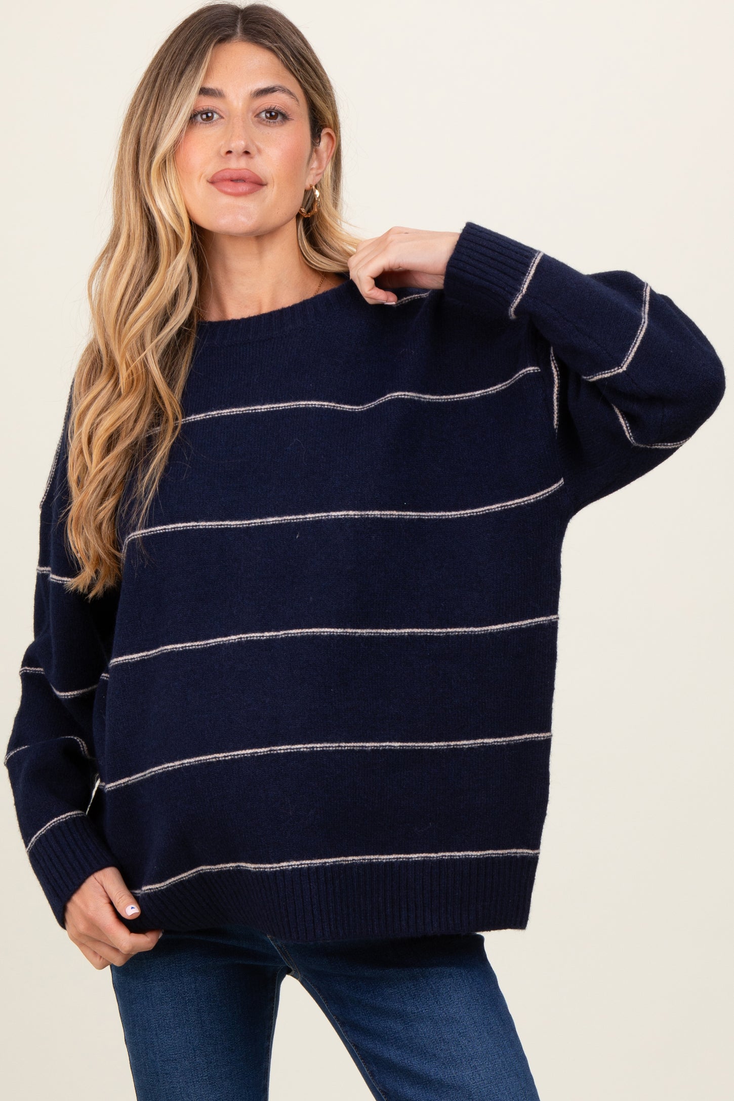 woman wearing a navy blue striped oversized maternity sweater with long sleeves and a relaxed fit
