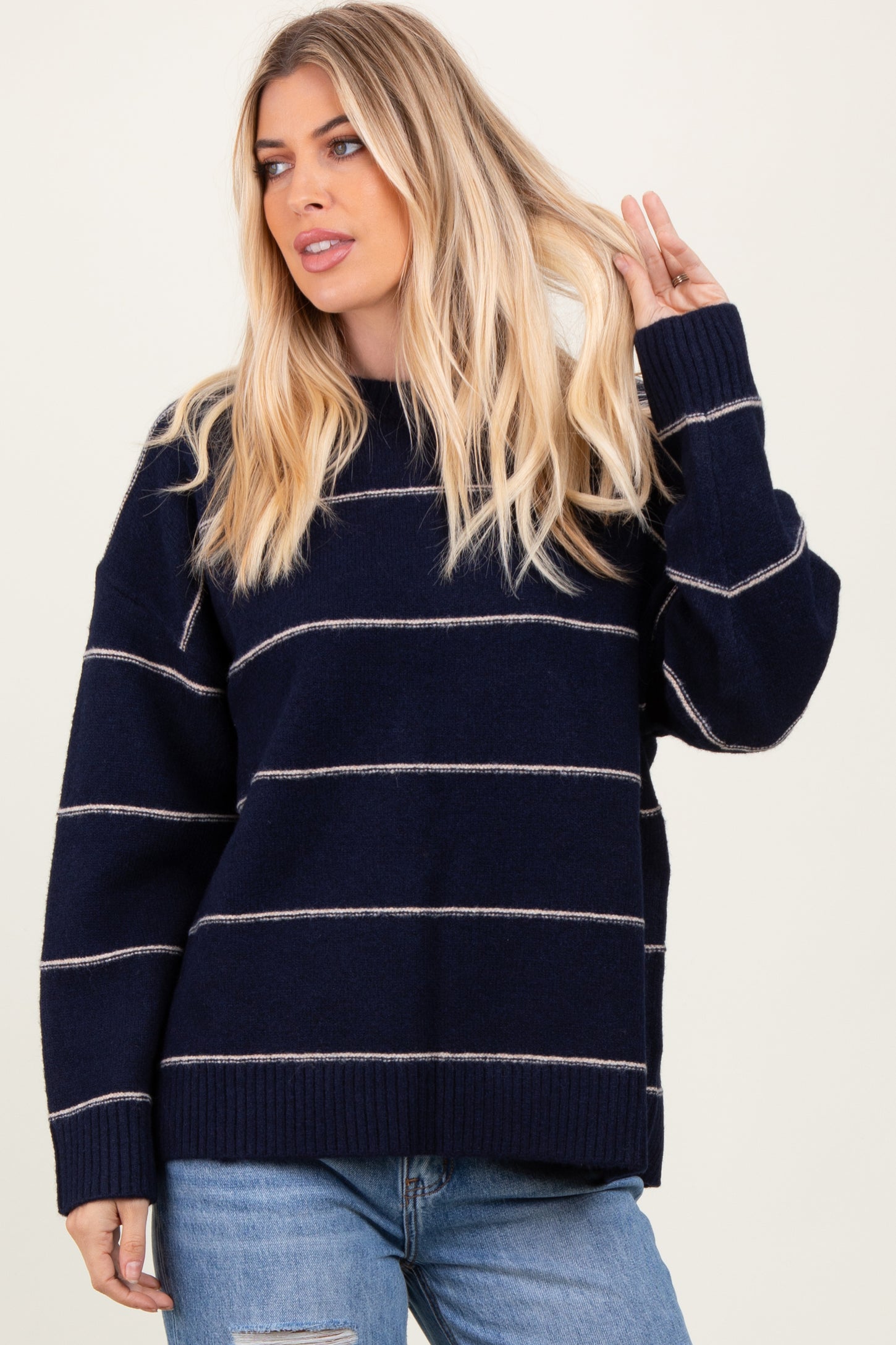 woman wearing a navy blue striped oversized sweater with long sleeves and relaxed fit