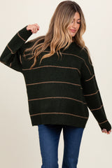 woman wearing a dark green striped oversized maternity sweater with a relaxed fit