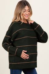 woman wearing a dark green striped maternity sweater and cradling her baby bump