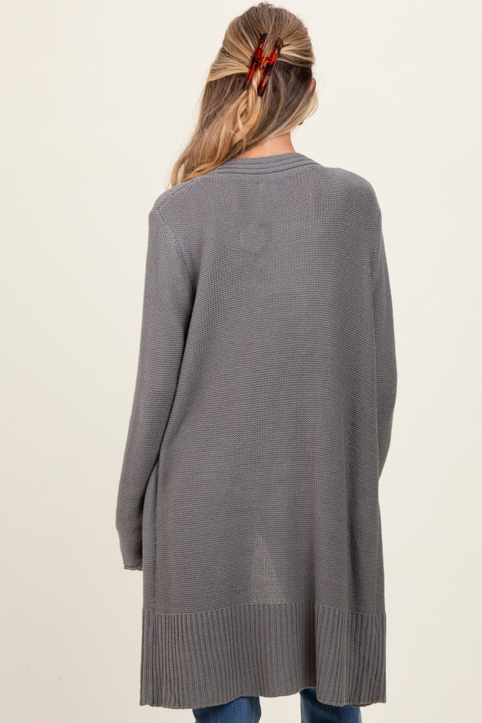 woman wearing a long gray maternity cardigan with an open back style and a relaxed fit