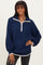 woman wearing a navy blue quarter-zip fleece pullover with white trim and balloon sleeves