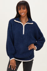 woman wearing a navy blue quarter-zip fleece pullover with white trim and balloon sleeves