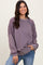 woman wearing a lavender long sleeve sweatshirt with intricate lace details and a relaxed fit