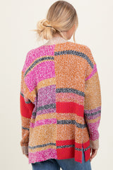 woman wearing a multicolored oversized sweater with a patchwork design and a cozy knit texture
