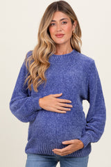 woman wearing a purple maternity sweater with a ribbed neckline and holding her baby bump