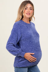 woman wearing a purple maternity sweater with a relaxed fit and holding her baby bump