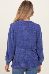 woman wearing a blue maternity sweater with a loose fit and ribbed hem, showing the back view