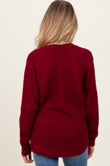 woman wearing a burgundy knit maternity sweater with a relaxed fit, shown from the back