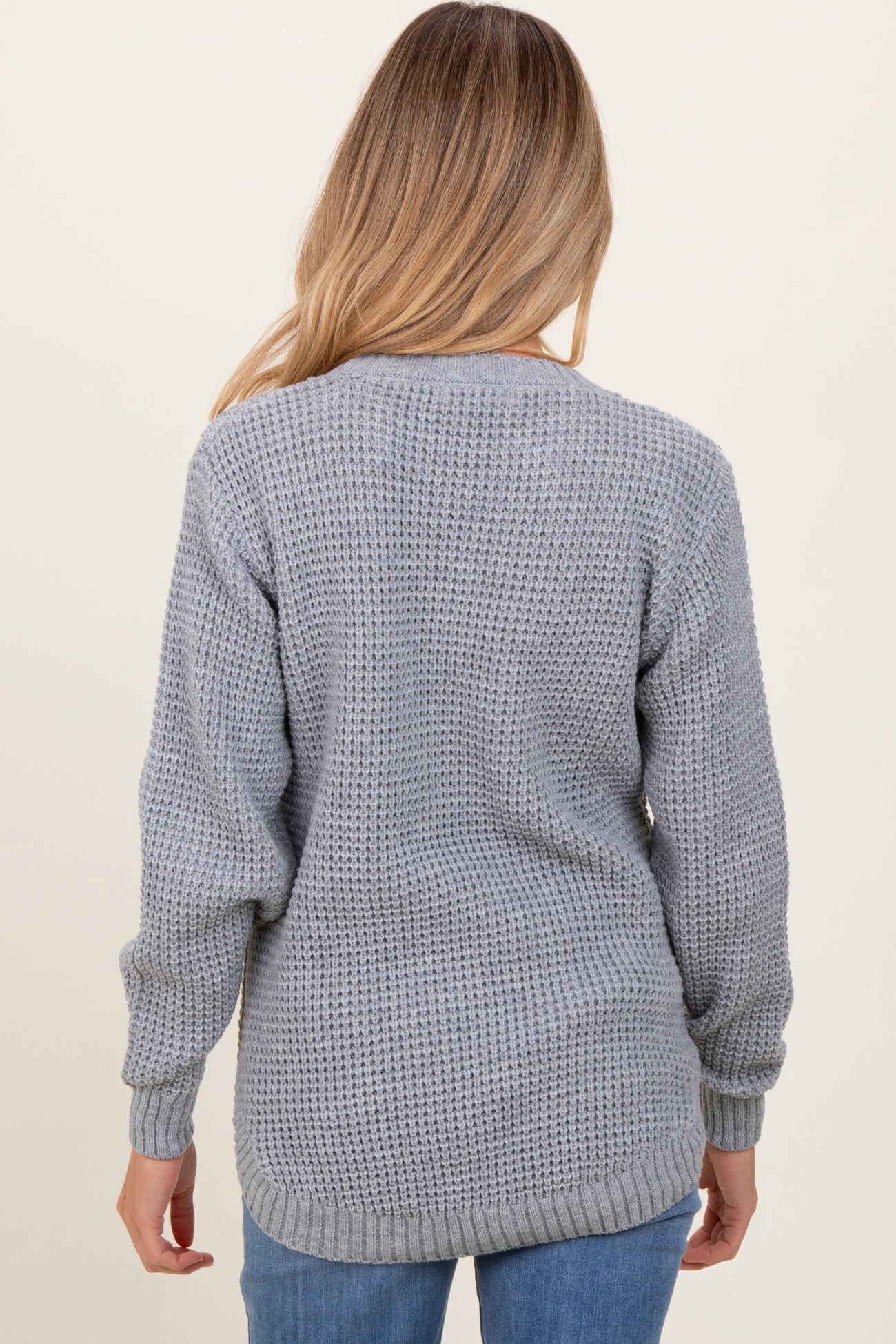 woman wearing a gray knit maternity sweater with a relaxed fit and long sleeves, viewed from the back