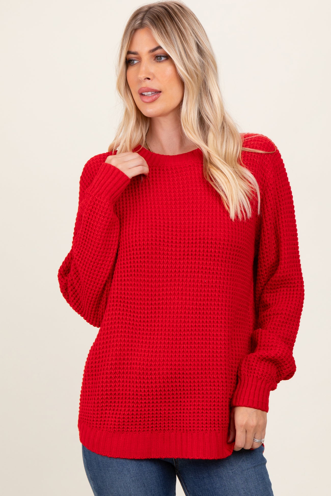 woman wearing a red oversized knit sweater with long sleeves and a relaxed fit