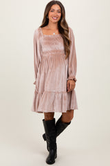 woman wearing a dusty rose maternity dress with smocking detail and tiered hem, paired with knee-high black boots