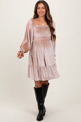 woman wearing a dusty rose maternity dress with smocked bodice and balloon sleeves, posing in knee-high black boots