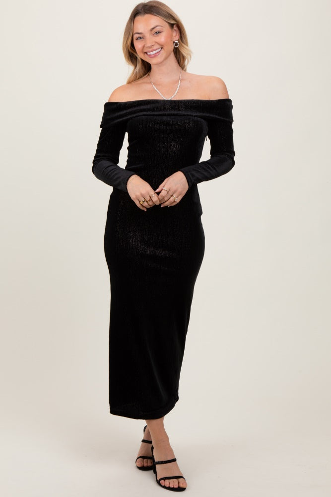 woman wearing a black off-the-shoulder maxi dress with long sleeves and a fitted silhouette
