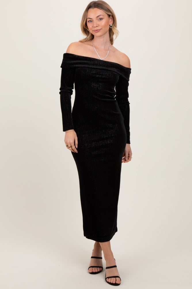 woman wearing a black off-the-shoulder long sleeve velvet dress with a fitted silhouette and a slit at the back