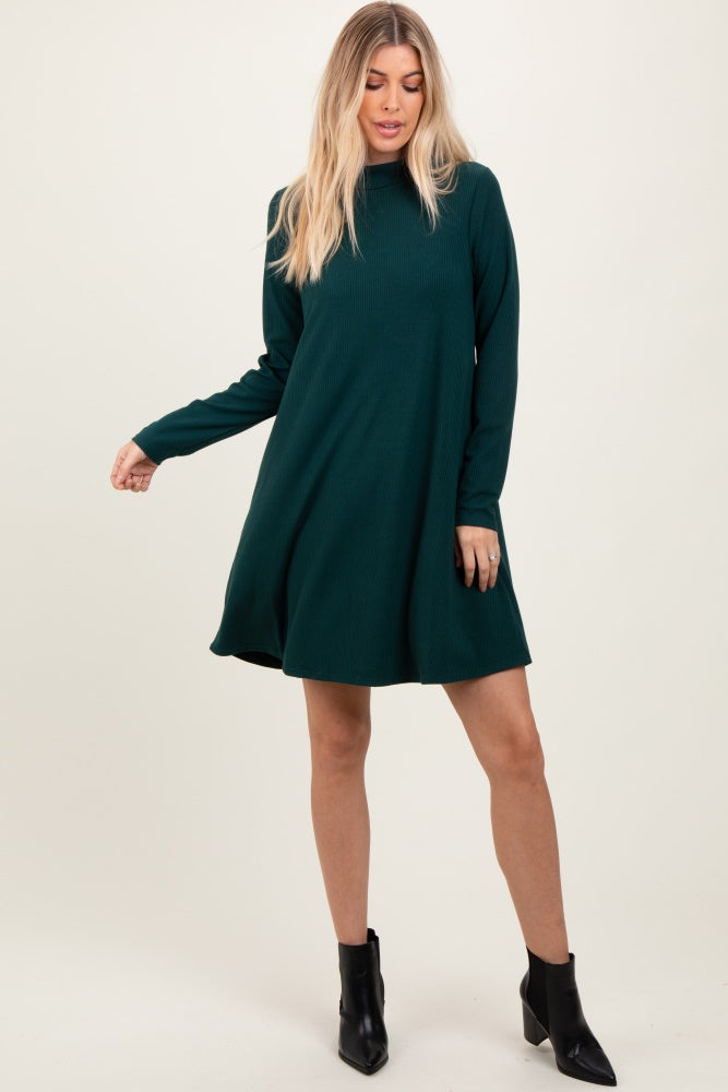 woman wearing a dark green long sleeve ribbed dress with a relaxed fit and black ankle boots