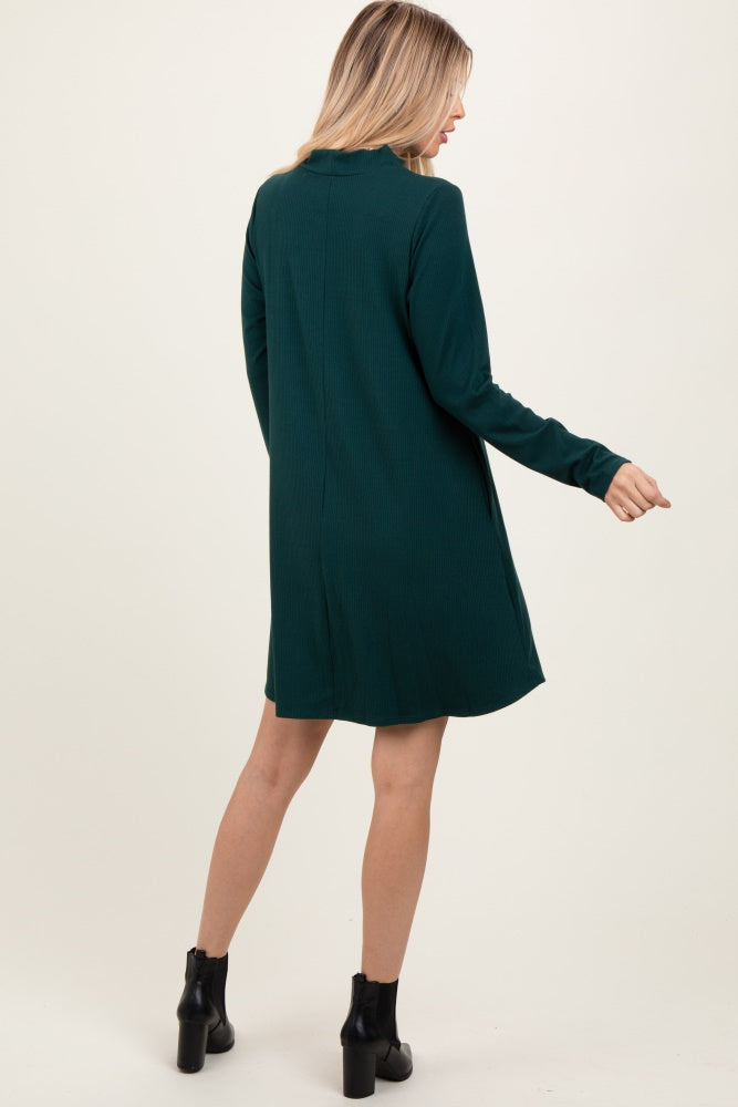 woman wearing a dark green long sleeve sweater dress with a relaxed fit, shown from the back