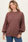 woman wearing a brown oversized sweater with balloon sleeves and a relaxed fit