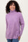 woman wearing a lavender turtleneck sweater with ribbed detailing and relaxed fit.