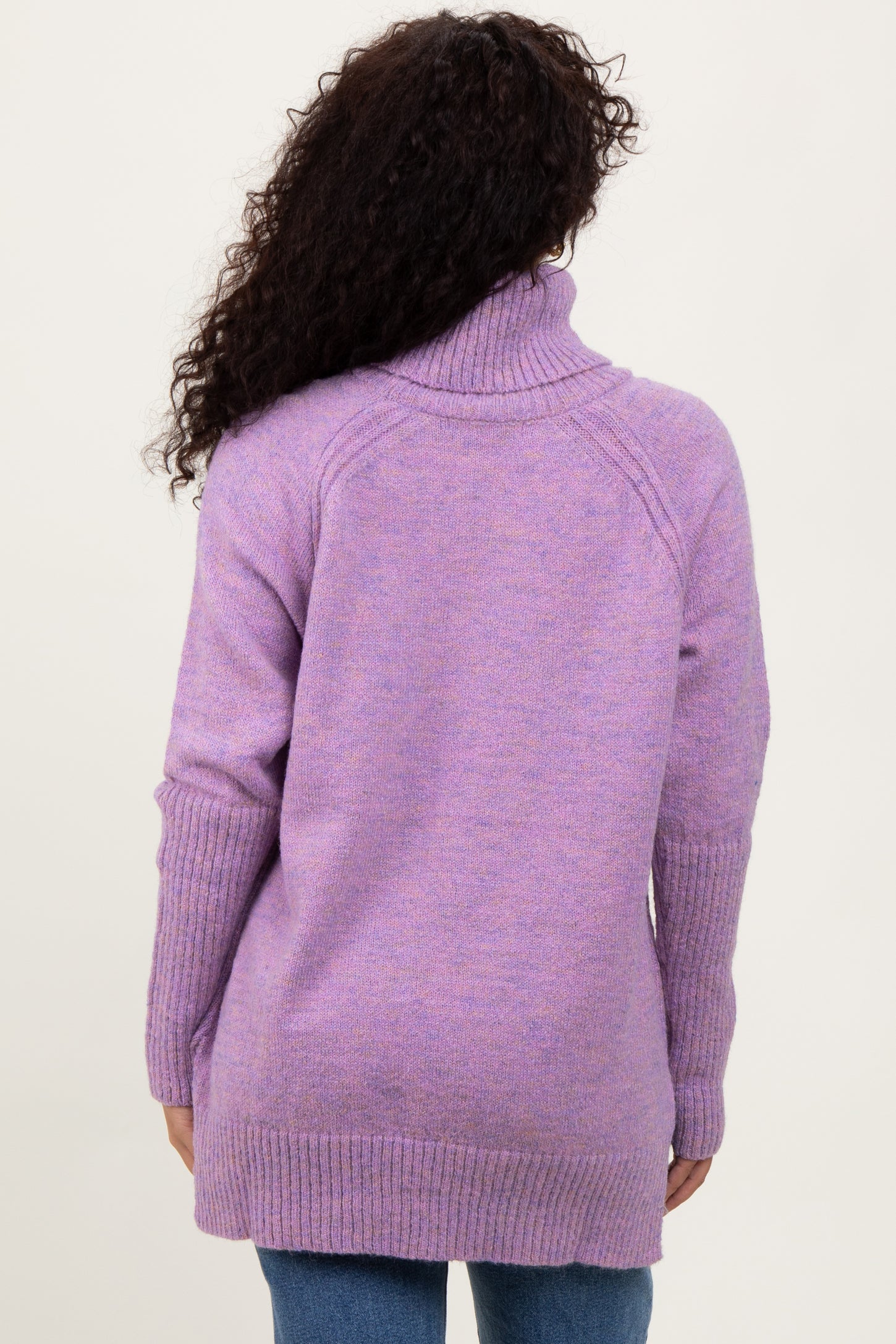 woman wearing a lavender oversized turtleneck sweater, viewed from the back