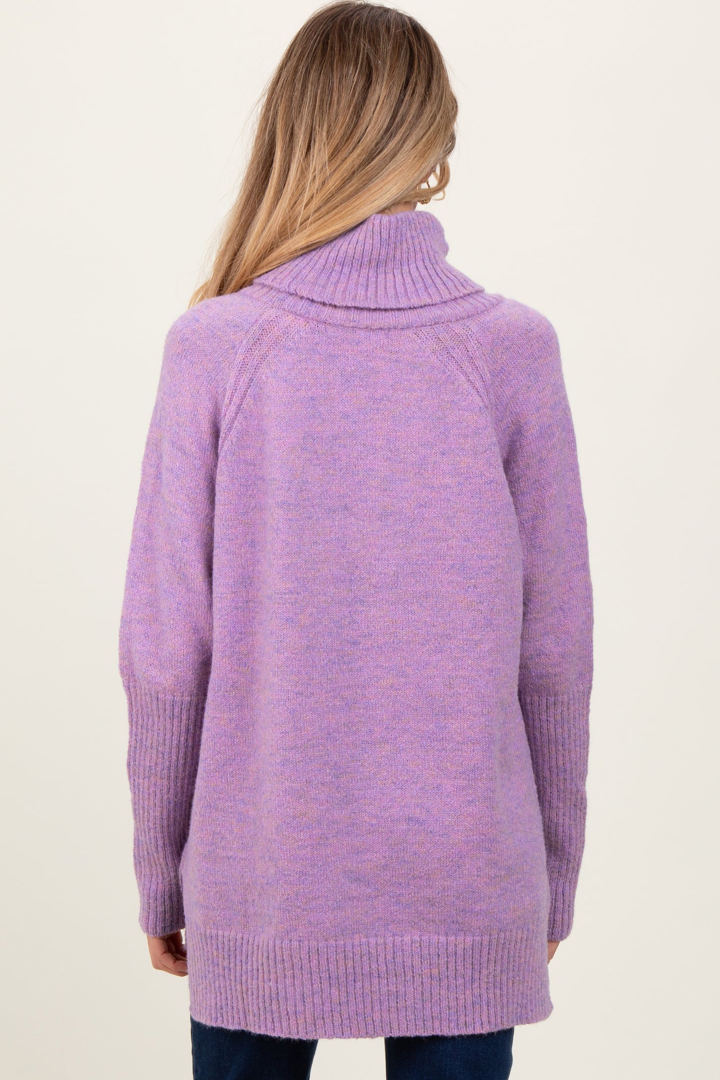 woman wearing a lavender maternity sweater with a turtleneck and ribbed cuffs, shown from the back