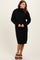 woman wearing a black turtleneck sweater dress with long sleeves and ribbed hemline