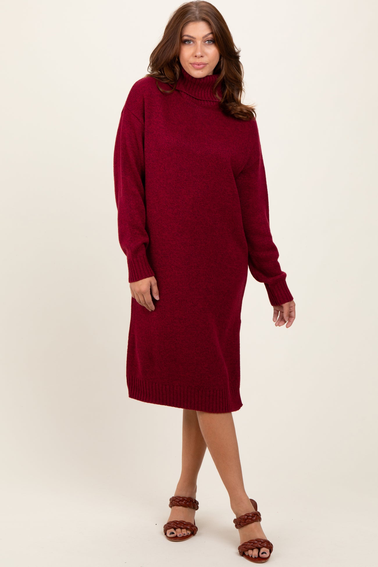 woman wearing a maroon turtleneck sweater dress with long sleeves and a relaxed fit