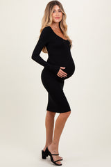 woman wearing a black long sleeve maternity dress and holding her baby bump