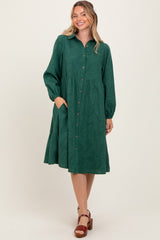 woman wearing a green long sleeve button-up dress with a flared skirt and pockets