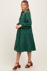 woman wearing a green patterned midi dress with balloon sleeves and a button-up front, styled with brown heeled sandals