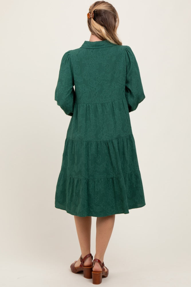 woman wearing a green tiered midi dress with long sleeves and a collar, shown from the back