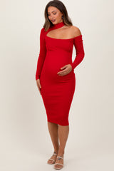 woman wearing a red off-the-shoulder maternity dress with a cut-out detail and holding her baby bump