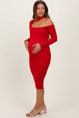 woman wearing a red off-shoulder maternity dress and showing her baby bump