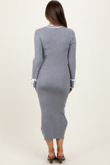 woman wearing a gray ribbed maternity dress with long sleeves and white tie details at the cuffs, showing a baby bump