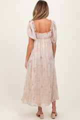 woman wearing a light pink floral maternity maxi dress with puff sleeves, showing a relaxed fit from the back