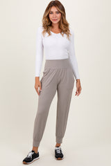 woman wearing a white long sleeve ribbed top and light gray jogger pants with a high waistband and side pockets