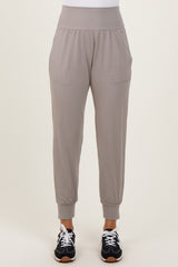 woman wearing light grey jogger pants with side pockets and elastic cuffs, paired with black athletic shoes
