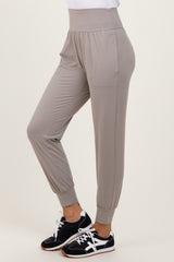 woman wearing light grey casual jogger pants with side pockets and elastic cuffs, paired with black sneakers
