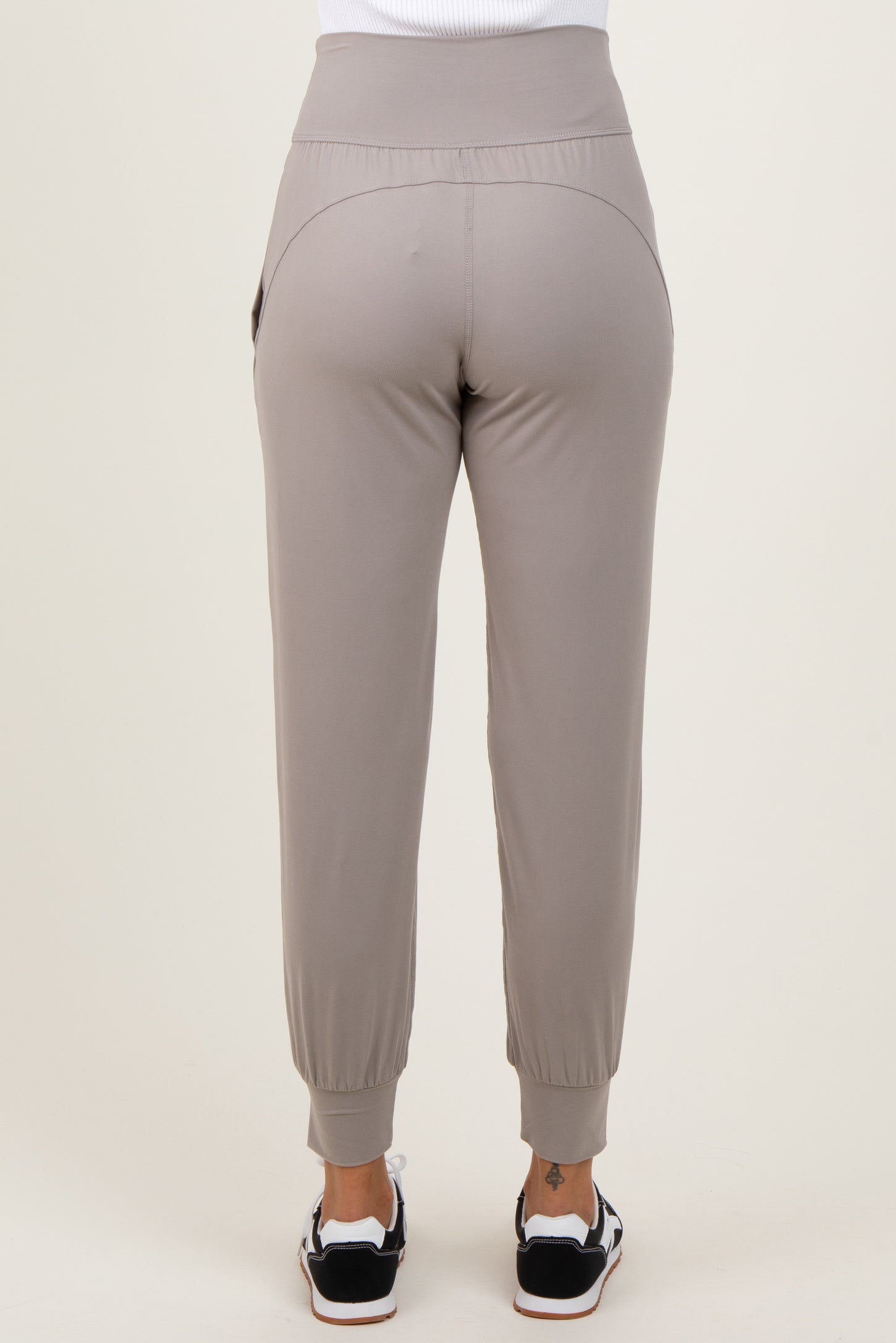 woman wearing light grey jogger pants with elastic waistband and cuffed ankles, shown from the back